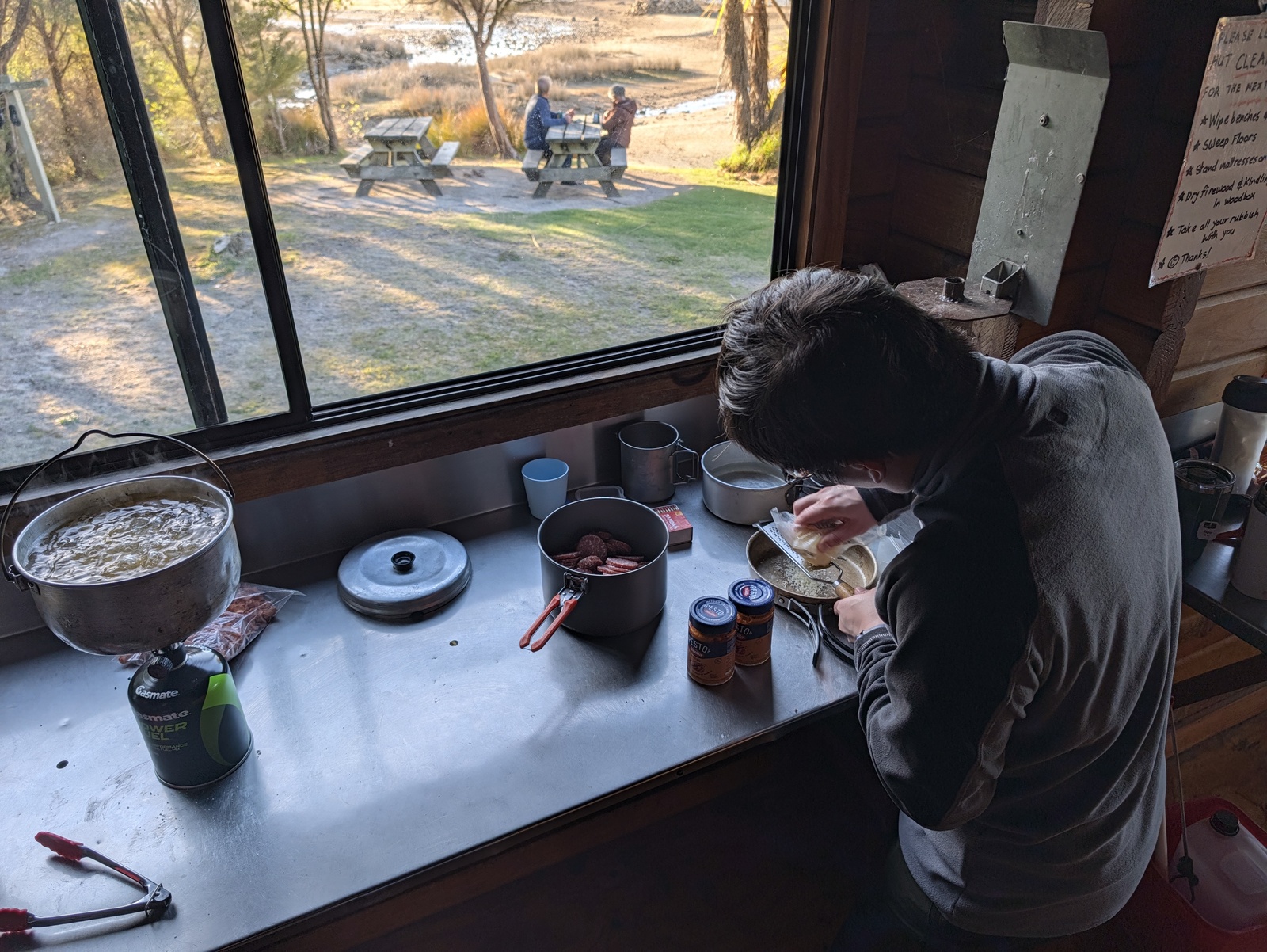 Preparing dinner (pasta, tomato pesto, and salami) on our last night, at Awaroa Hut